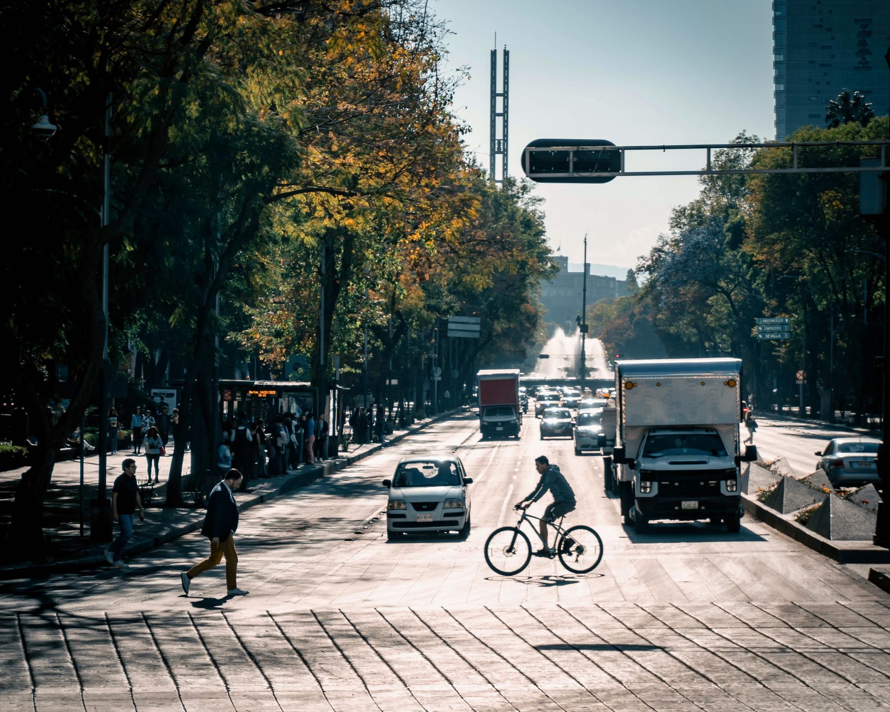 Camión de reparto y ciclista en una avenida de la Ciudad de México