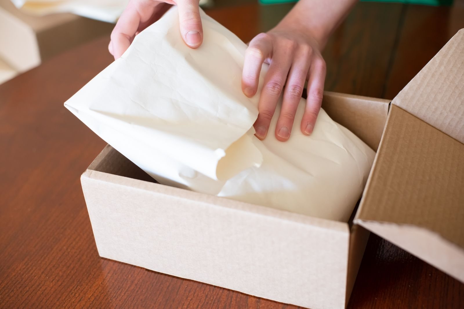 Manos empacando un pedido en una caja